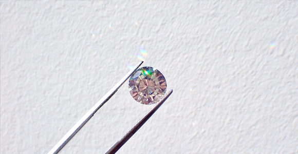 Image of diamond held by a pair of tweezers