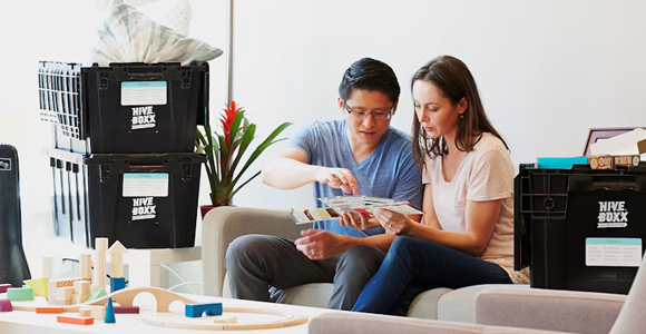 Photo of two parents reviewing a document together while sitting on a couch
